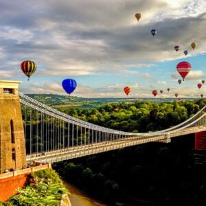 Hot air balloons over suspension bridge